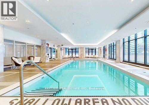 A large indoor swimming pool with a sign that says "SALON AREA NO DIPPING".