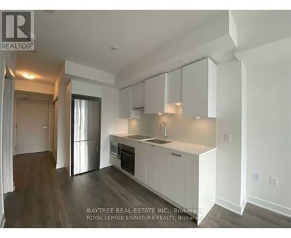 A kitchen with white cabinets and a stainless steel refrigerator.