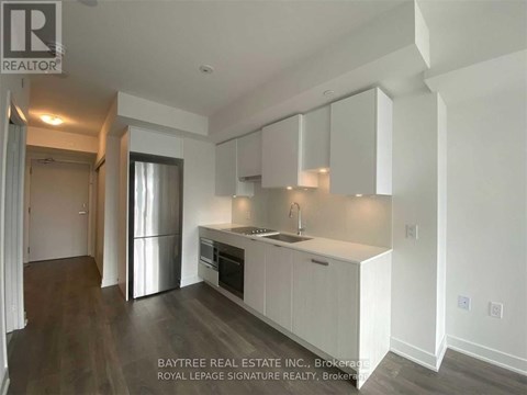 A kitchen with white cabinets and a stainless steel refrigerator.