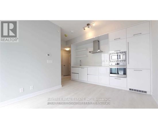 A white kitchen with a microwave and oven built into the cabinetry.