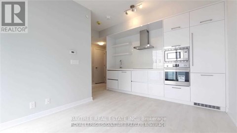 A white kitchen with a microwave and oven built into the cabinetry.