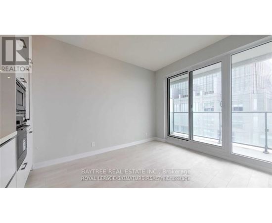 A white room with a window and a sign that says Baytree Real Estate Inc.