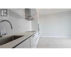 A kitchen with a sink and a stove top oven.