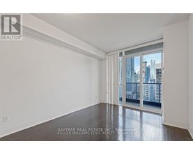 A spacious room with a view of the city through the sliding glass doors.
