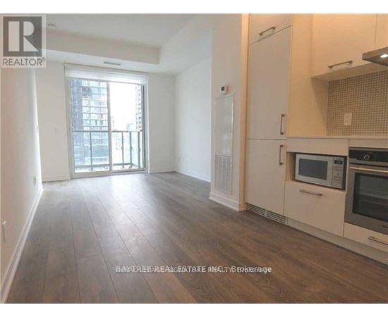 A well-lit kitchen with wooden floors and modern appliances.