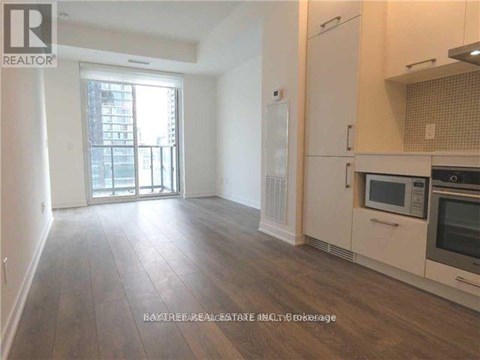 A well-lit kitchen with wooden floors and modern appliances.