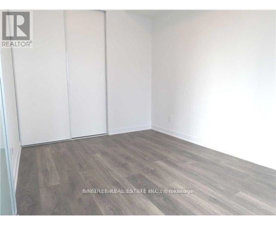 A room with wooden flooring and white walls.