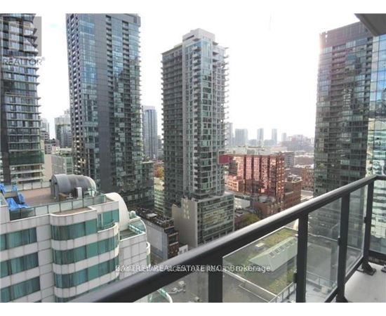 A cityscape with apartment buildings and a balcony in the foreground.
