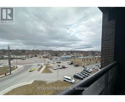 A parking lot with cars and a building in the background.