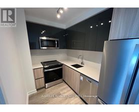 A modern kitchen with stainless steel appliances and wooden cabinets.