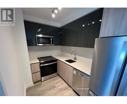 A modern kitchen with stainless steel appliances and wooden cabinets.