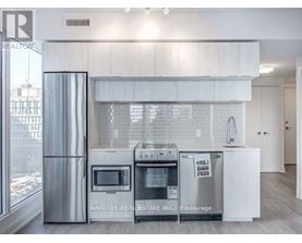 A modern kitchen with white cabinets and stainless steel appliances.