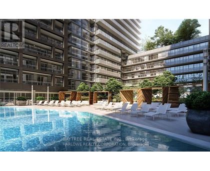A pool area with lounge chairs and a building in the background.