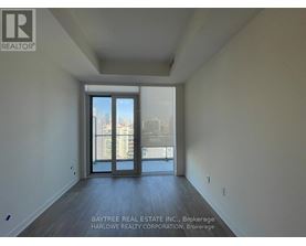 A spacious room with a view of the city through the sliding glass doors.