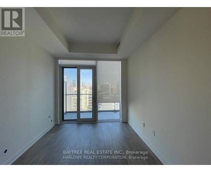 A spacious room with a view of the city through the sliding glass doors.