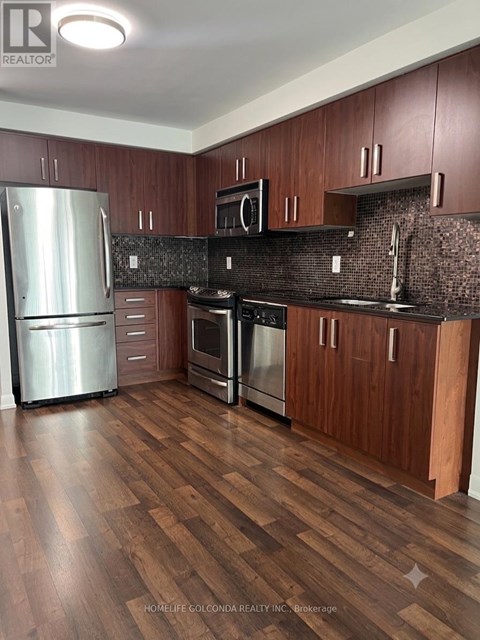 A kitchen with wooden cabinets and a black countertop.