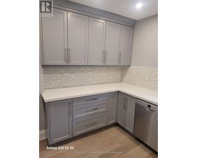 A kitchen with white cabinets and a stainless steel dishwasher.