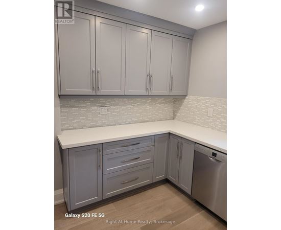 A kitchen with white cabinets and a stainless steel dishwasher.