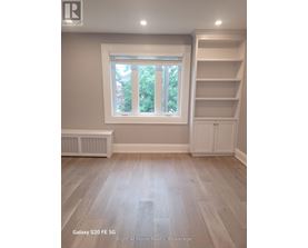 A room with a window and a shelf unit.