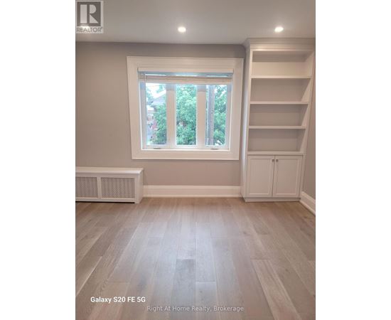 A room with a window and a shelf unit.