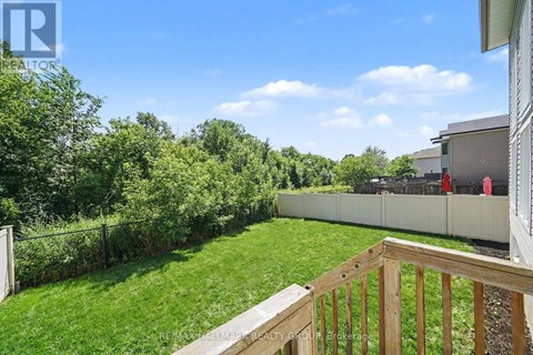 A backyard with a wooden deck and a fence.