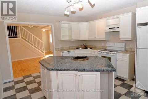 A kitchen with white cabinets and a granite countertop.