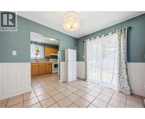 A kitchen with a white refrigerator and a white cabinet.