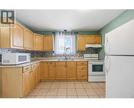 A kitchen with wooden cabinets and a white refrigerator.