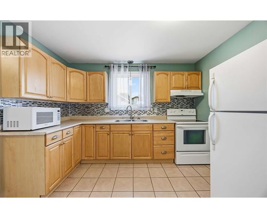 A kitchen with wooden cabinets and a white refrigerator.