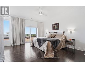 A bedroom with a large bed and a ceiling fan.