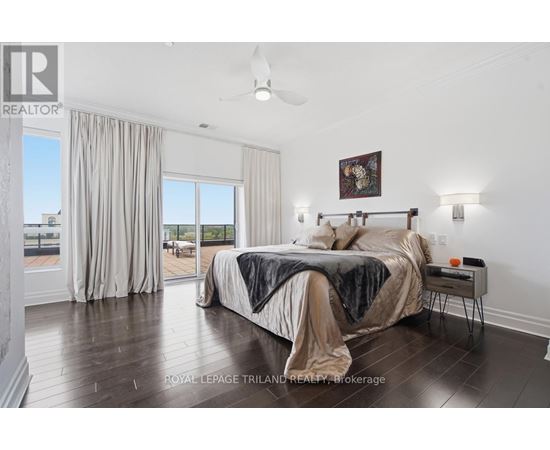 A bedroom with a large bed and a ceiling fan.