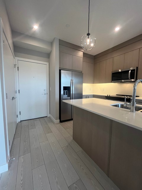 A kitchen with a sink and a refrigerator.