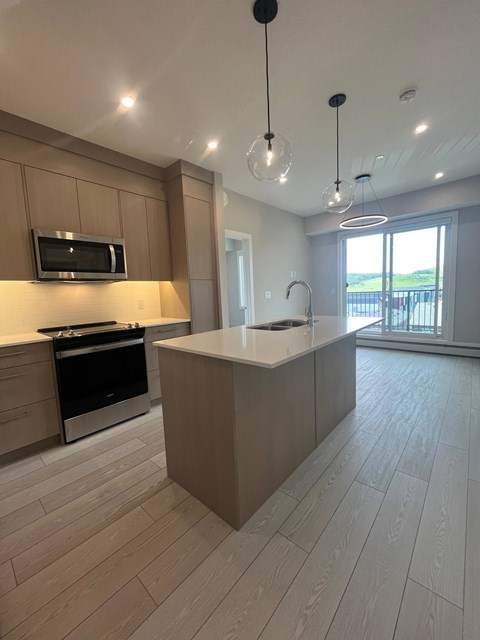 A modern kitchen with wooden cabinets and a large island.