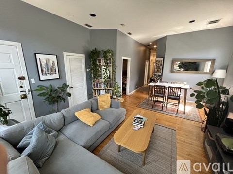 A living room with a grey couch and a wooden coffee table.