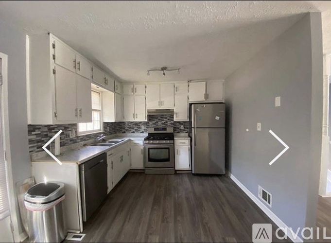 A kitchen with white cabinets and a stainless steel refrigerator.