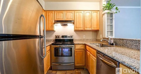 A kitchen with wooden cabinets and a stainless steel refrigerator.