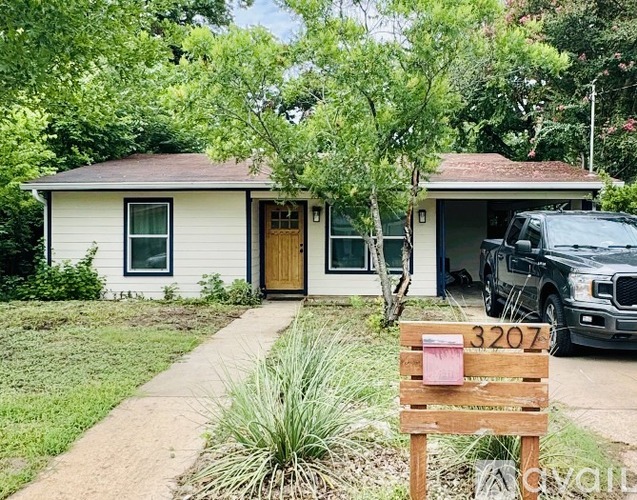 A house with a brown door and a sign in front of it.