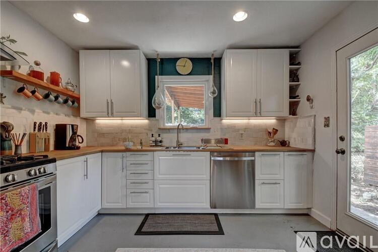 A kitchen with white cabinets and a stove top oven.