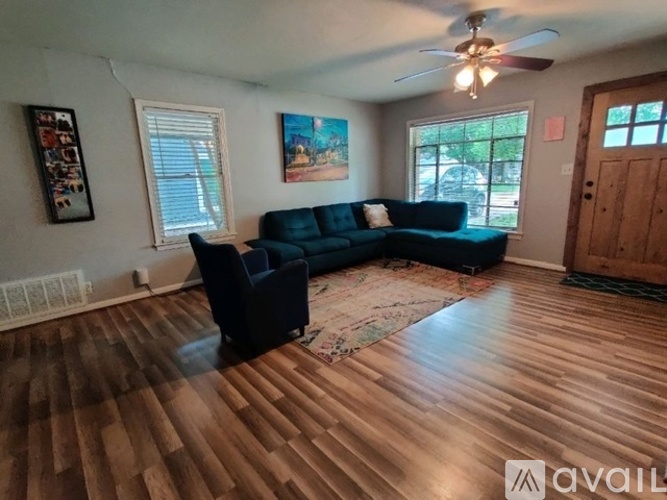 A living room with a blue couch and a rug.