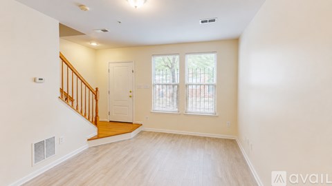 A spacious room with a staircase leading to the upper floor.