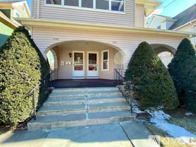 A house with a front yard and steps leading to the entrance.