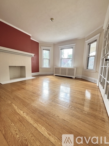 A room with wooden flooring and a fireplace.