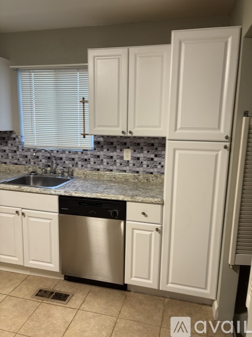 A kitchen with white cabinets and a granite countertop.