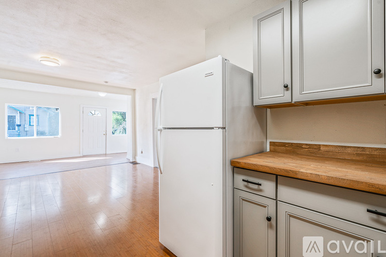 A kitchen with a white fridge and wooden countertops.