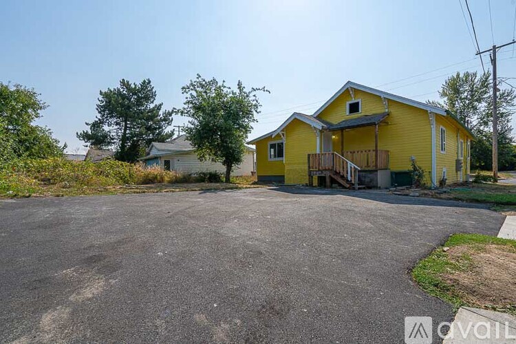 A yellow house with a driveway in front.