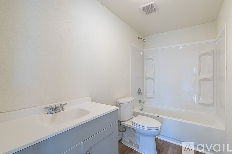 A white bathroom with a toilet, sink, and bathtub.