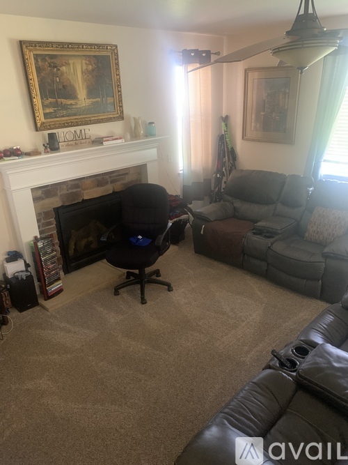 A living room with a fireplace and a grey couch.