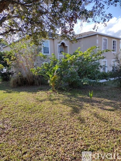 A house with a lawn and trees in front of it.