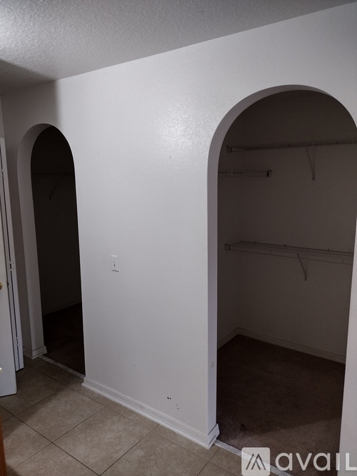 A room with a white wall and a doorway leading to another room.