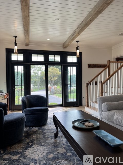 A living room with a black couch and a wooden coffee table.